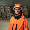 Nicklas Johansson, Platschef i Finland, står i en återvinningsanläggning med skyddsutrustning. I bakgrunden återvunnet papper.