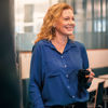 A close-up of a smiling female Stena Metall Group employee standing in an office environment.