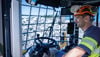 A production worker from Stena Aluminium in protective gear is sitting in the cab of a loader