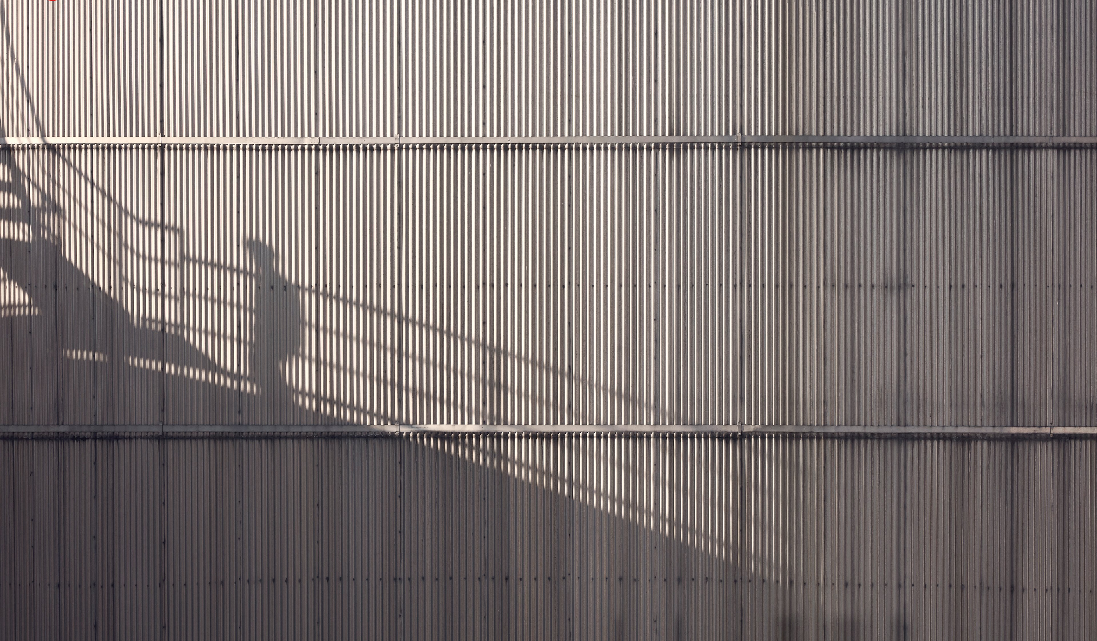 The shadow of a Stena Metall Group employee is shown high up on the side of a Stena facility.